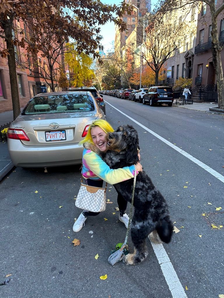 Britta hugging a big dog on a Manhattan brownstone street
